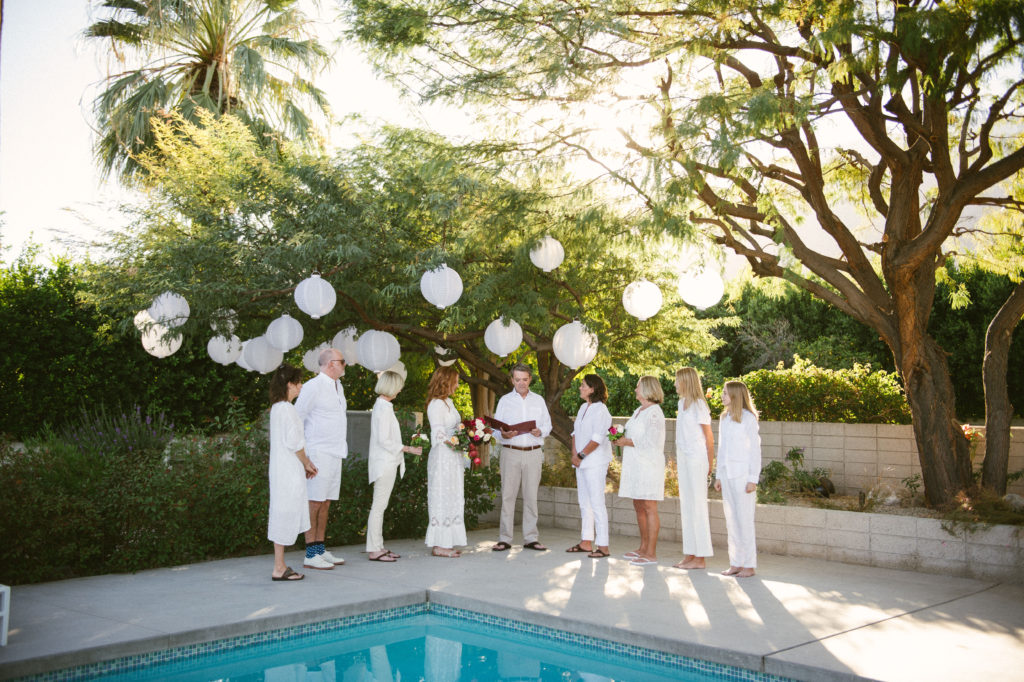 Wedding party around a pool all dressed in white