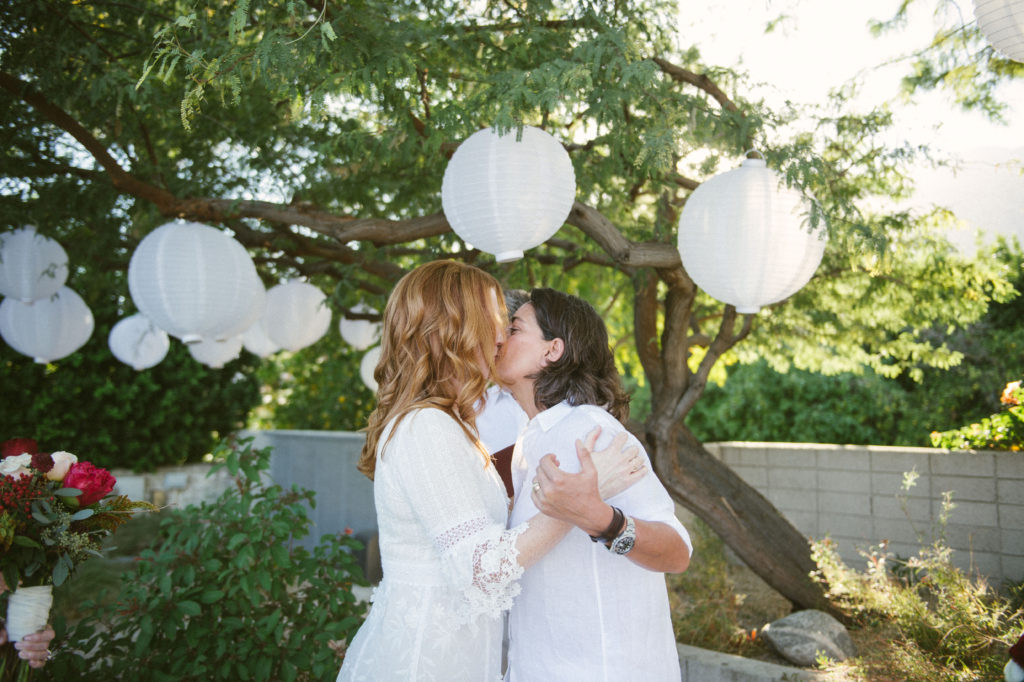 two brides kissing after wedding ceremony