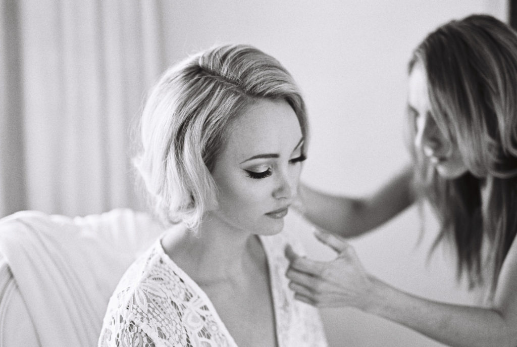Hair stylist grooming a bride on her wedding day
