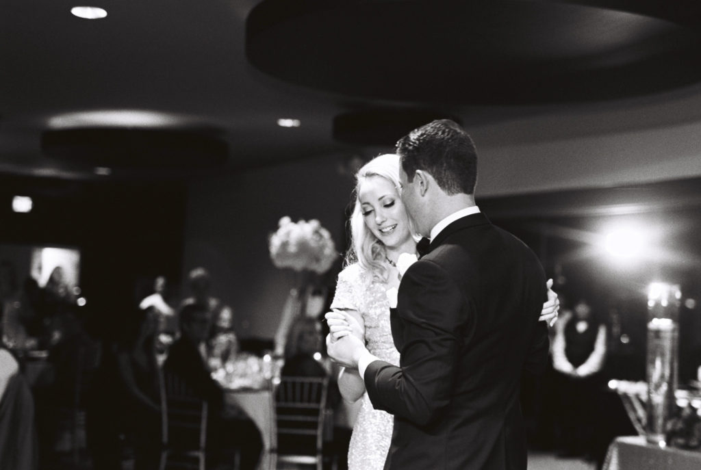 black and white film photo of bride and groom during their first dance at Spencer's Restaurant during the reception. 