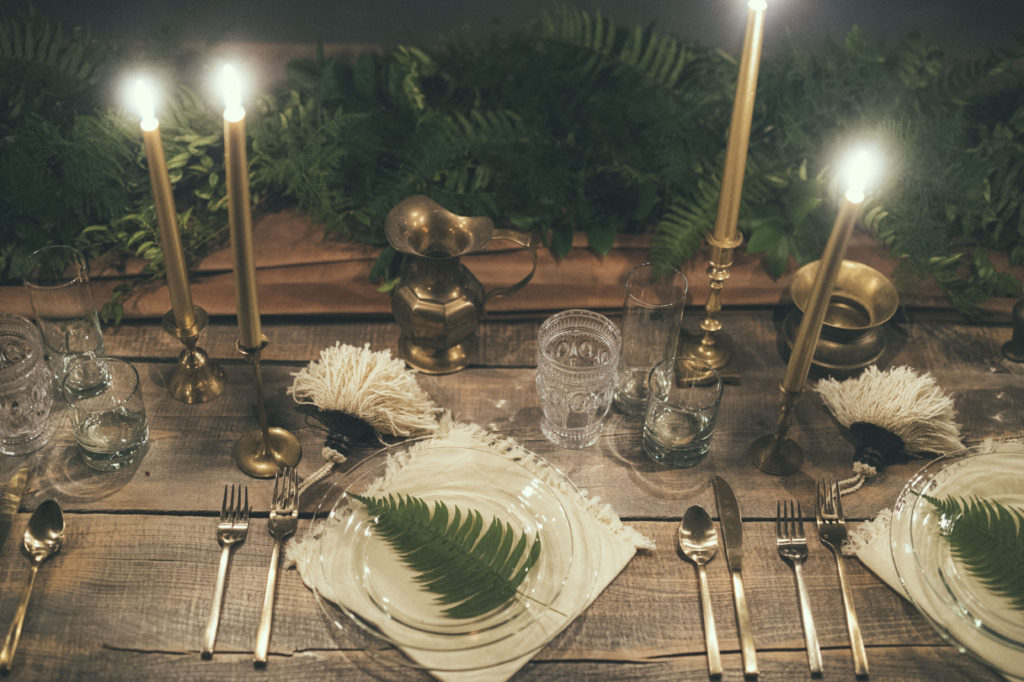 candlelit wedding reception table with fern decorations