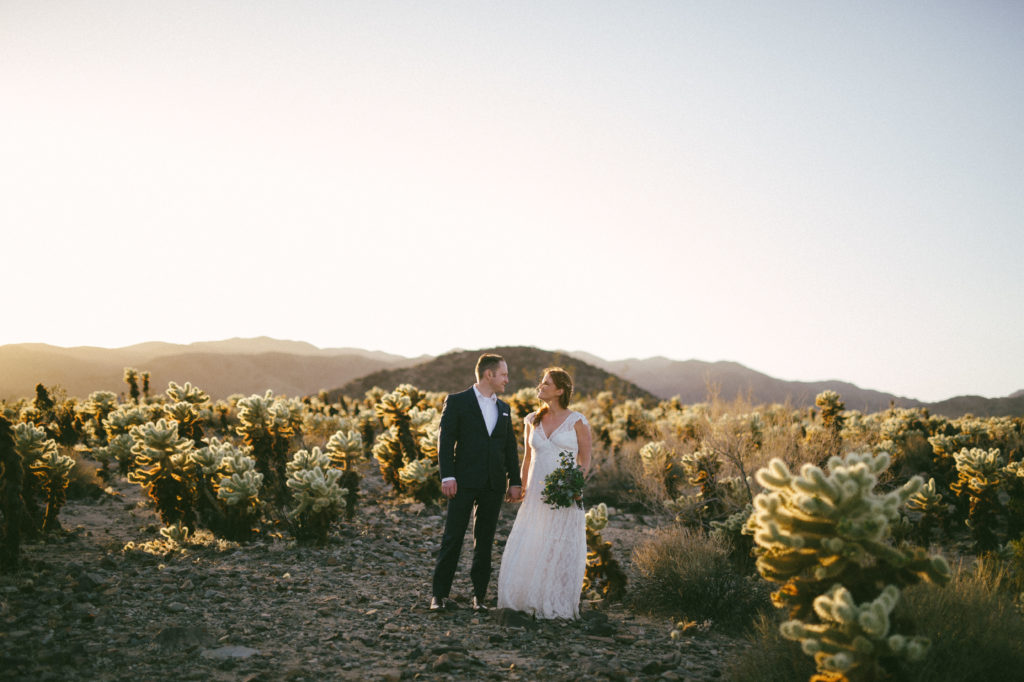 Bride and groom pose for a photo in Joshua Tree for their micro wedding. 