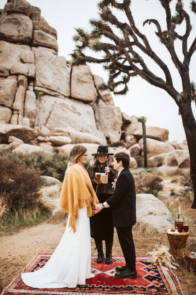 Two brides during their ceremony at their elopement in Joshua Tree