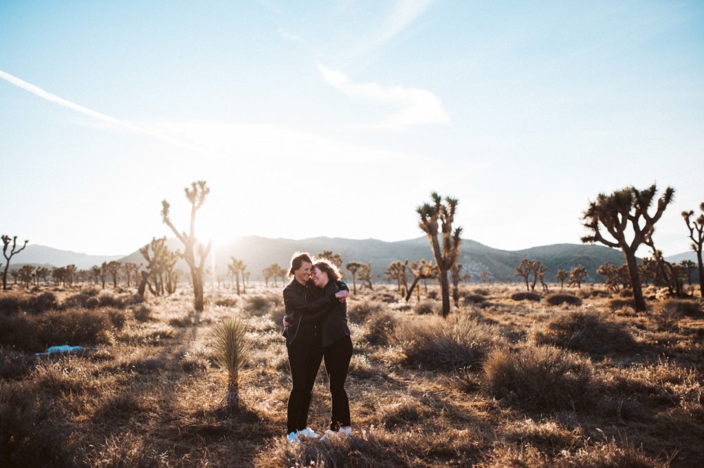 Two brides embracing during their elopement in Joshua Tree