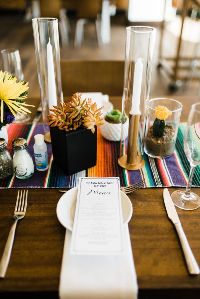 Place setting of a dinner table at a micro wedding with hand sanitizer at the table.