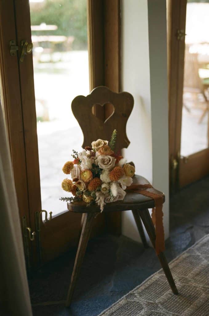 A set of Flowers sitting on a chair on wedding day
