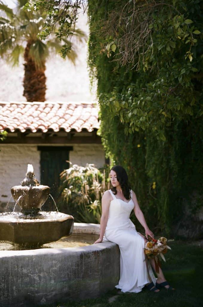 bride sitting on fountain