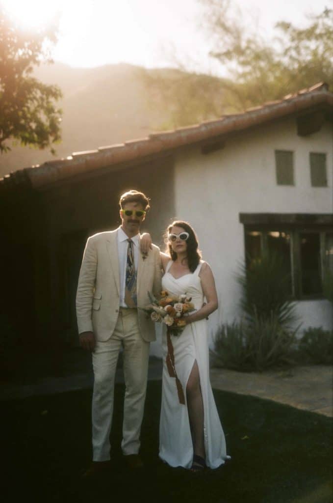 bride and groom pose for photo with sunglasses on

