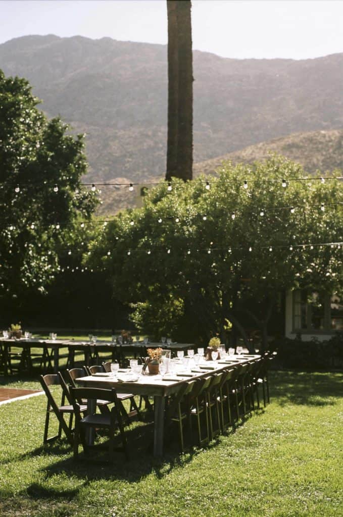 photo of reception decor on grass lawn in front of mountains