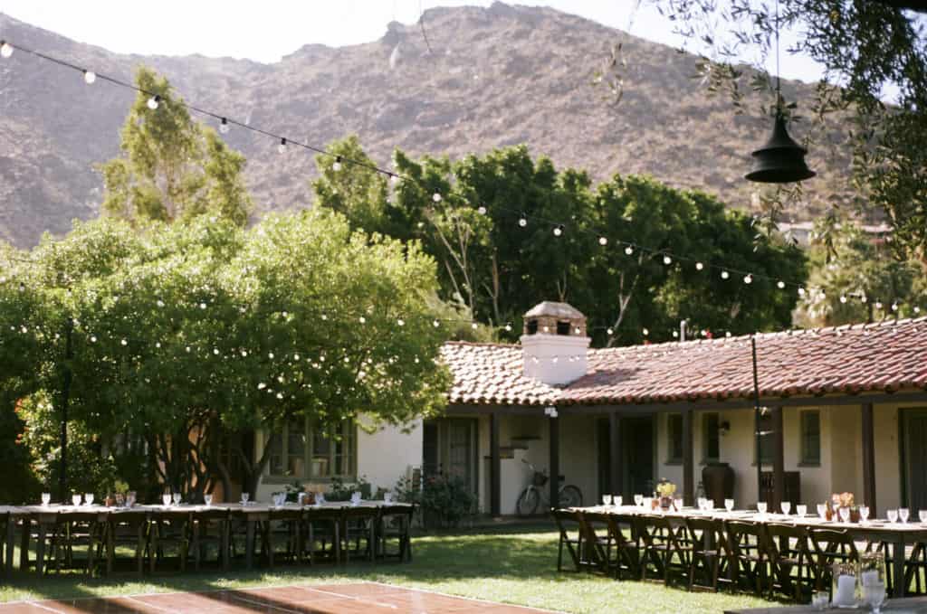 photo of reception decor on grass lawn in front of mountains